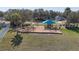 Community playground featuring a colorful play structure, swings, surrounded by green grass and residential homes at 1001 Willow Run St., Minneola, FL 34715