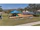 Community playground featuring a colorful play structure, swings, benches, and a bike rack near a scenic lakeside view at 1001 Willow Run St., Minneola, FL 34715