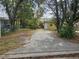 Yellow house with driveway, surrounded by trees at 1040 Maxey Dr, Winter Garden, FL 34787