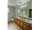 Bathroom boasts double vanity, large mirror, and tiled floor at 115 Cardamon Dr, Orlando, FL 32825