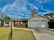 Single story home with attached garage and well-maintained lawn at 115 Cardamon Dr, Orlando, FL 32825