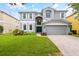 Two-story house with gray siding, a three-car garage, and a well-manicured lawn at 12666 Moss Park Ridge Dr, Orlando, FL 32832