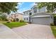 Two-story house with gray siding, paved driveway, and landscaped lawn at 12666 Moss Park Ridge Dr, Orlando, FL 32832