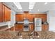 Modern kitchen with wood cabinets, granite countertops, and stainless steel appliances at 12666 Moss Park Ridge Dr, Orlando, FL 32832