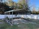 Metal storage shed in a backyard with a white vinyl fence at 14476 Se 34Th Ct, Summerfield, FL 34491