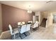 Elegant dining room with glass-top table and white chairs near staircase at 1584 Sandbagger Dr, Davenport, FL 33896