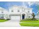 Two-story house with white exterior, stone accents, and a two-car garage at 1584 Sandbagger Dr, Davenport, FL 33896