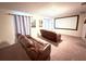 Home theater with brown leather reclining sofas and projector screen at 1584 Sandbagger Dr, Davenport, FL 33896