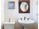 Small bathroom with pedestal sink and decorative mirror at 1601 Lyndale Blvd, Maitland, FL 32751