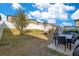 Wide backyard with a patio table set, playground area, and a firepit next to the white fence at 1778 Sundance Chase Rd, Minneola, FL 34715