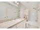 Bathroom with a wide mirror, ample counter space, and a shower-tub combo with a shower curtain at 1778 Sundance Chase Rd, Minneola, FL 34715