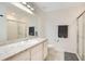Bathroom features a single sink vanity, a toilet, and a glass-enclosed shower with a gray accent mat at 1778 Sundance Chase Rd, Minneola, FL 34715