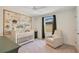 Bedroom with a Winnie the Pooh themed mural, a white crib, and a glider in front of a window at 1778 Sundance Chase Rd, Minneola, FL 34715