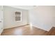 Empty bedroom with neutral walls, wood-look floors, a window, and a paneled door to the hallway at 1778 Sundance Chase Rd, Minneola, FL 34715