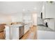 Bright kitchen features stainless steel appliances, granite counters, white cabinets, and wood flooring at 1778 Sundance Chase Rd, Minneola, FL 34715