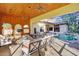 Relaxing covered patio with fire pit, pool view, and comfortable seating at 1829 Brackenhurst Pl, Lake Mary, FL 32746