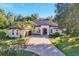 Single-story home with tile roof, large driveway, and lush landscaping at 1829 Brackenhurst Pl, Lake Mary, FL 32746