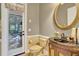 Elegant powder room with dark vanity and a large circular mirror at 1829 Brackenhurst Pl, Lake Mary, FL 32746