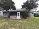 Home featuring an enclosed porch, mature shade trees, and lush lawn at 1886 Elkcam Blvd, Deltona, FL 32725
