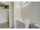 Bathroom featuring white vanity, cabinet, toilet, and a large doorway leading to a tiled floor at 1886 Elkcam Blvd, Deltona, FL 32725