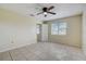 Sunny bedroom featuring tile flooring, a ceiling fan, and a window providing natural light at 1886 Elkcam Blvd, Deltona, FL 32725