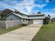 View of home with long driveway and attached garage at 1886 Elkcam Blvd, Deltona, FL 32725