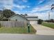 Home exterior with a long driveway leading to an attached garage at 1886 Elkcam Blvd, Deltona, FL 32725