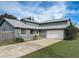 Home exterior with driveway leading to garage at 1886 Elkcam Blvd, Deltona, FL 32725