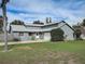 Charming single-story home with well-maintained landscaping, a paved driveway, and an attached garage at 1886 Elkcam Blvd, Deltona, FL 32725