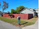 Home featuring lush green lawn, healthy shade trees, and mature red wooden fence at 1886 Elkcam Blvd, Deltona, FL 32725