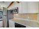 A kitchen with a stainless steel refrigerator, a countertop, and white cabinetry at 1886 Elkcam Blvd, Deltona, FL 32725