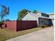 Home featuring green exterior, bright trim, new roof, and mature red wooden fence at 1886 Elkcam Blvd, Deltona, FL 32725