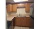 Efficient kitchen with wood cabinets, stainless steel sink, and essential appliances, ready for cooking at 1928 Conway Rd # 27, Orlando, FL 32812