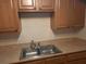 Functional kitchen featuring ample wood cabinetry and a stainless steel double sink for easy meal prep at 1928 Conway Rd # 27, Orlando, FL 32812