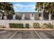 Charming condo building with lush tropical landscaping, including palm trees and manicured bushes and white fence at 1928 Conway Rd # 40, Orlando, FL 32812