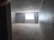 Spacious living room with gray carpet, walls, and trim; a window allows natural light to flow in at 1928 Conway Rd # 40, Orlando, FL 32812