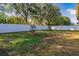 Spacious backyard with a white vinyl fence and young trees at 2147 Sunbow Ave, Apopka, FL 32703