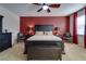 Bright bedroom with a king-size bed and red accent wall at 2147 Sunbow Ave, Apopka, FL 32703
