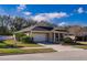Tan house with a two-car garage and landscaping at 2147 Sunbow Ave, Apopka, FL 32703