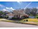 Tan house with a two-car garage and landscaping at 2147 Sunbow Ave, Apopka, FL 32703