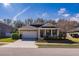 Tan house with a two-car garage and landscaping at 2147 Sunbow Ave, Apopka, FL 32703