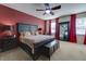 Spacious Primary bedroom with king bed and red accent wall at 2147 Sunbow Ave, Apopka, FL 32703