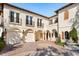 Elegant courtyard entry with fountain and arched garage doors at 236 Acadia Ter, Celebration, FL 34747