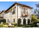 White stucco home with balcony, decorative iron railings, and lush landscaping at 236 Acadia Ter, Celebration, FL 34747