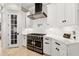 Modern kitchen with black and stainless gas range, white cabinets and marble backsplash at 236 Acadia Ter, Celebration, FL 34747