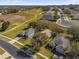 Aerial view showcasing homes near a golf course at 2513 Castle Pines St, Clermont, FL 34711