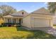 Tan one-story house with a two-car garage and well-manicured lawn at 2513 Castle Pines St, Clermont, FL 34711