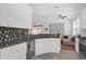 Modern kitchen with white cabinets, granite countertops, and stainless steel appliances at 2513 Castle Pines St, Clermont, FL 34711