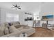 Bright living room with open floor plan, L-shaped sectional sofa, and kitchen views at 2513 Castle Pines St, Clermont, FL 34711