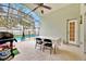 Enclosed patio with pool access, table, chairs, and grill at 2627 Oneida Loop, Kissimmee, FL 34747